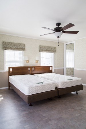 清潔感の高い明るい色調のベッドルーム、白いモールディング、幅木はデザインアクセント。